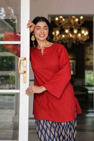 Rosalie red cotton kurta with loop-detailed neckline and navy paisley printed Farshi salwar, model posing by a doorway