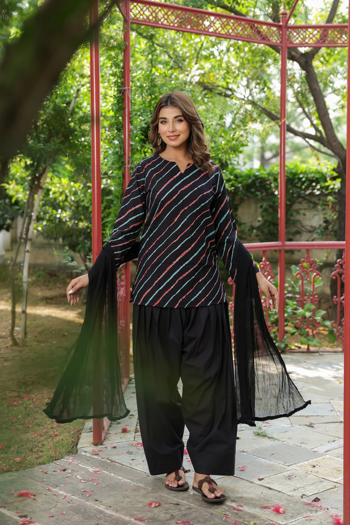 Model wearing Elara Black Leheriya Cotton Farshi Salwar Suit Set with multicolour diagonal striped kurta, black Farshi salwar and matching dupatta